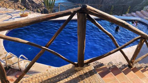 una piscina con acqua blu e una recinzione in legno di Hotel Gambusino a Lázaro Cárdenas
