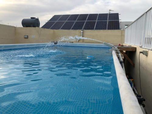 a swimming pool with a water fountain at Luqa Rooms in Luqa