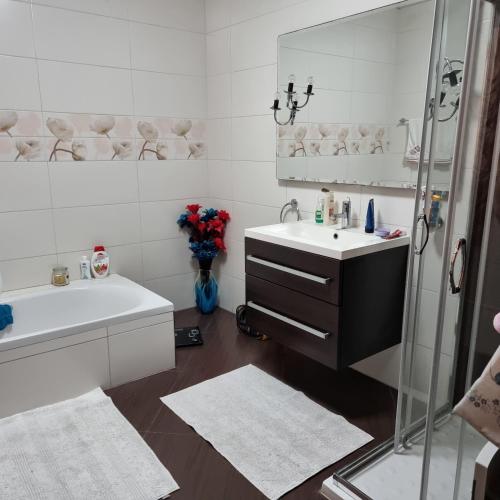 a white bathroom with a sink and a shower at Luqa Rooms in Luqa