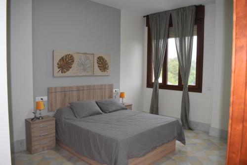 a bedroom with a bed and a window at FIBES Lux Sevilla Este. in Seville