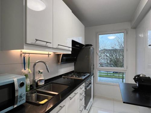 une cuisine avec évier et cuisinière ainsi qu'une fenêtre dans l'établissement location 3 chambres spacieuses dans appartment 2 mn RER Bussy Saint georges, à Bussy-Saint-Georges