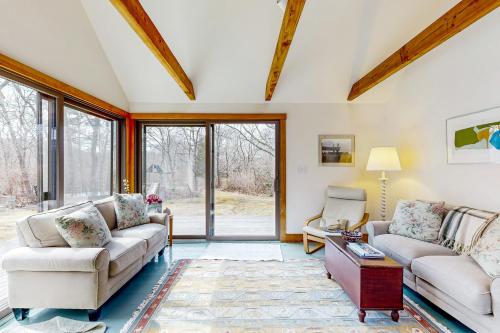 a living room with two couches and a table at Chilmark Guest House in Chilmark