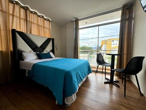 a bedroom with a bed and a table and a window at Las Condes II in Cajamarca