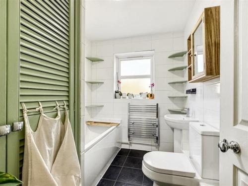 a white bathroom with a toilet and a sink at Victoria Cam in Cambridge