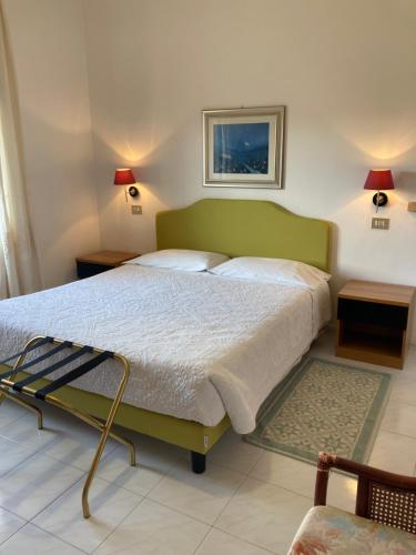 a bedroom with a large bed with a green headboard at Hotel La Capannina in Aritzo