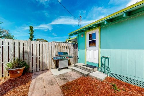 a blue house with a fence next to it at Bayfront Bliss Retreat in Marco Island