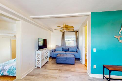 a living room with a blue couch and a tv at Bayfront Bliss Retreat in Marco Island