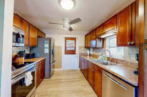 a kitchen with wooden cabinets and a stainless steel refrigerator at Bayfront Bliss Retreat in Marco Island