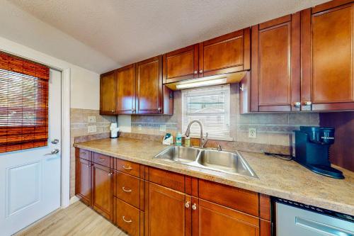 a kitchen with wooden cabinets and a sink at Bayfront Bliss Retreat in Marco Island
