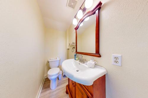 a bathroom with a sink and a toilet and a mirror at Bayfront Bliss Retreat in Marco Island