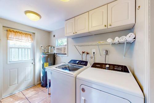 a small kitchen with a washer and dryer in it at Bayfront Bliss Retreat in Marco Island