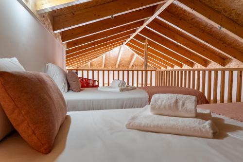 two beds in a room with a attic at City Hall Apartments in Vila Real