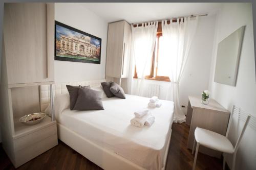 ein Schlafzimmer mit einem weißen Bett mit zwei Teddybären darauf in der Unterkunft Roman Holidays all'Eur in Rom