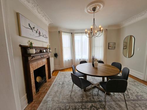 a dining room with a table and a fireplace at Ottawa Downtown Cozy Guesthouse in Ottawa
