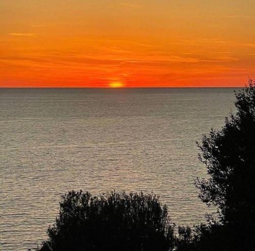 zachód słońca nad oceanem i słońce w oddali w obiekcie Sunrise Village Cilento w mieście Pisciotta