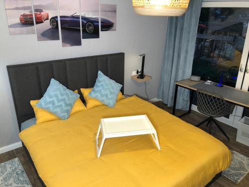 a bedroom with a yellow bed with a table on it at Stylisches Maybach Appartement mit Terrasse für 5-7 Personen, 5 Betten, große Kochinsel, Homeoffice mit 250Mbit WLAN in Aidlingen