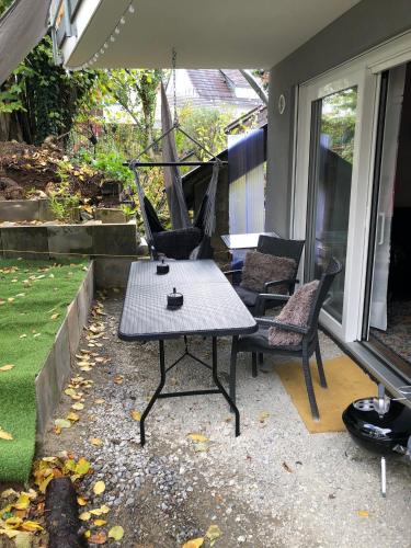 a patio with a table and chairs on a porch at Stylisches Maybach Appartement mit Terrasse für 5 Personen, 5 Betten, große Kochinsel, Homeoffice mit 250Mbit WLAN in Aidlingen