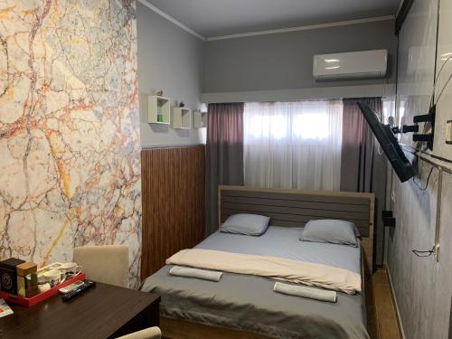 a small bedroom with a bed and a map on the wall at Apartman Dacaa in Podgorica