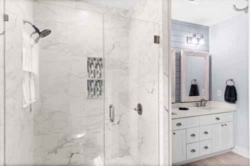 a white bathroom with a shower and a sink at Live Oak Villa~OKI Beach Retreat in Oak Island