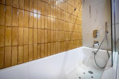 a bathroom with a tub and a shower with wooden walls at Hotel Duomo Firenze in Florence