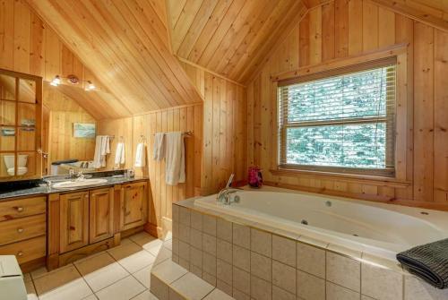 baño grande con bañera y lavamanos en Fiddler Lake Resort Chalet Moose 33 en Mille-Isles