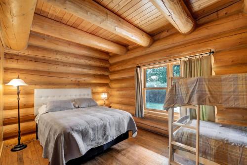 a bedroom with a bed in a log cabin at Fiddler Lake Resort Chalet Moose 33 in Mille-Isles