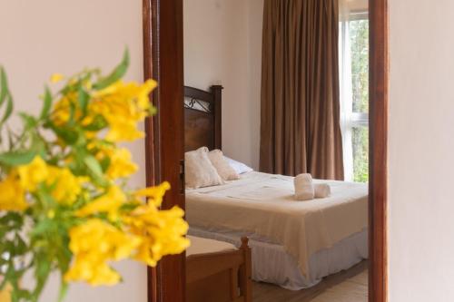 a bedroom with a mirror and a bed with yellow flowers at Habitación con amplia terraza en Encarnacion in Encarnación