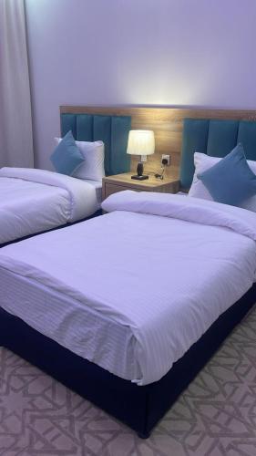 two beds sitting next to each other in a bedroom at ضيف بارك للشقق المخدومة in Ad Dawādimī