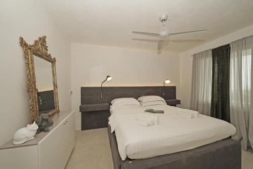 a bedroom with a large bed and a mirror at Villa Dolce Bellezza in Salò