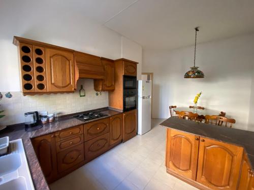 uma cozinha com armários de madeira e uma mesa em Bright and spacious Double Room, shared bathroom em Tal-Għoqod