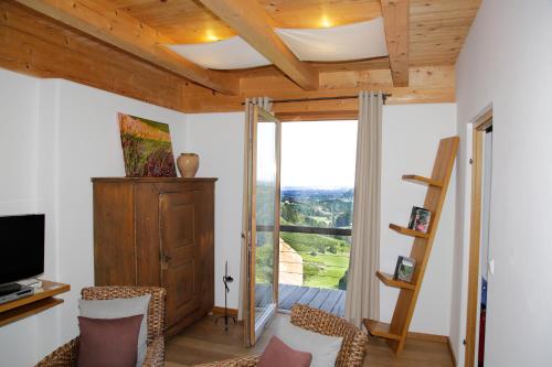 ein Wohnzimmer mit einem großen Fenster und einem TV in der Unterkunft Ferienhäuser "Am Grassnitzberg" in Spielfeld