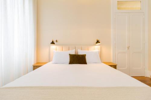 - une chambre avec un grand lit blanc et des oreillers blancs dans l'établissement Canto do Atlantico - City Centre, à Ponta Delgada