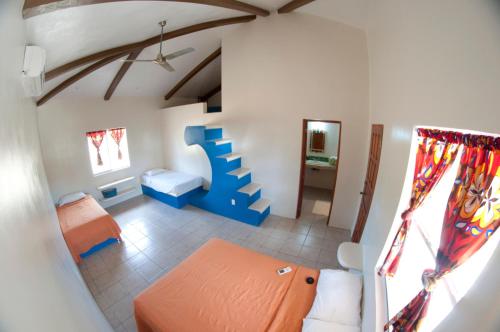 una habitación con sofá y cama en una casa en Surf Sanctuary, en El Limón