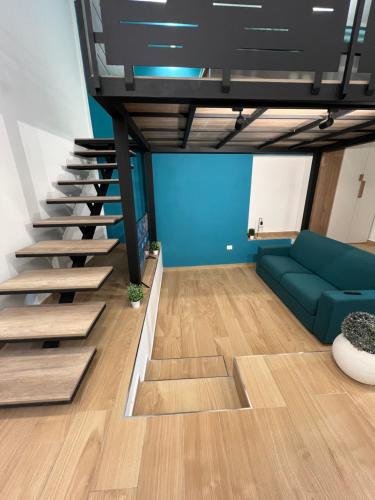 a living room with a green couch and stairs at Da Lello: Luxury Loft strategico in Marigliano
