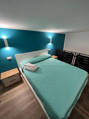 Schlafzimmer mit einem Bett mit blauer Wand in der Unterkunft Da Lello: Luxury Loft strategico in Marigliano