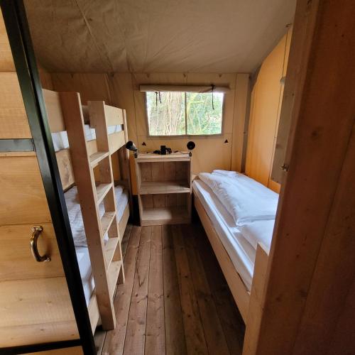 ein kleines Zimmer mit 2 Etagenbetten und einem Fenster in der Unterkunft Heated & brand new Forestlodge in Renesse