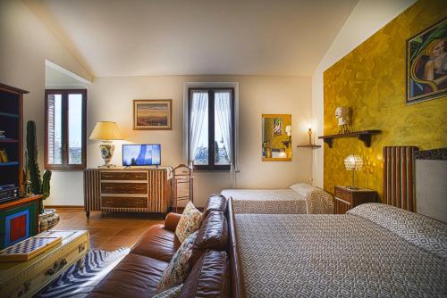 uma sala de estar com duas camas e um sofá em Villa Elvira 1931 em Siena