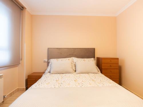Un dormitorio con una cama grande con ropa de cama blanca. en Apartamento "EL PEDROSO", en Tordesillas