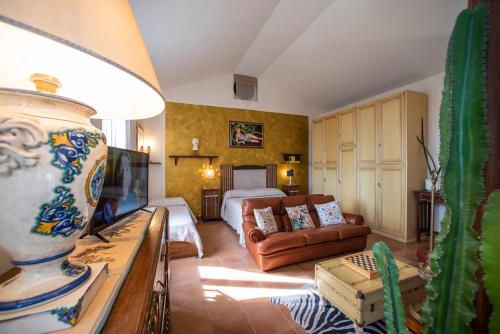 a living room with a couch and a television at Villa Elvira 1931 in Siena