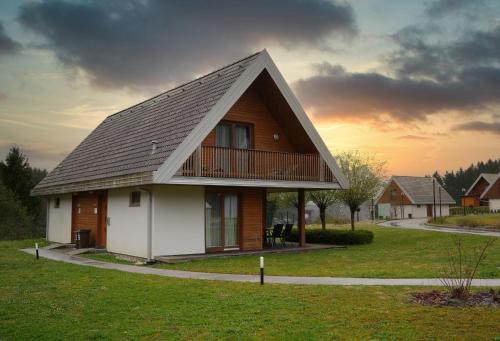 a house with a gambrel roof on top of it at Apartma Pikabooth in Topolšica