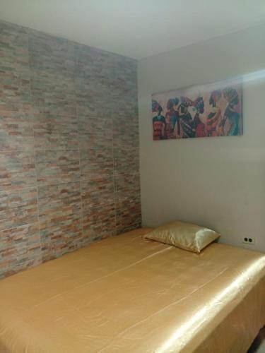 Bett in einem Zimmer mit Ziegelwand in der Unterkunft Estudio Comodo y Tranquilo in Mexicali