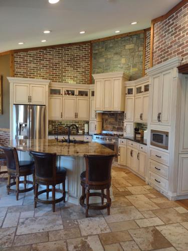a large kitchen with white cabinets and a large island at Golf Course Home - New Listing in Mason