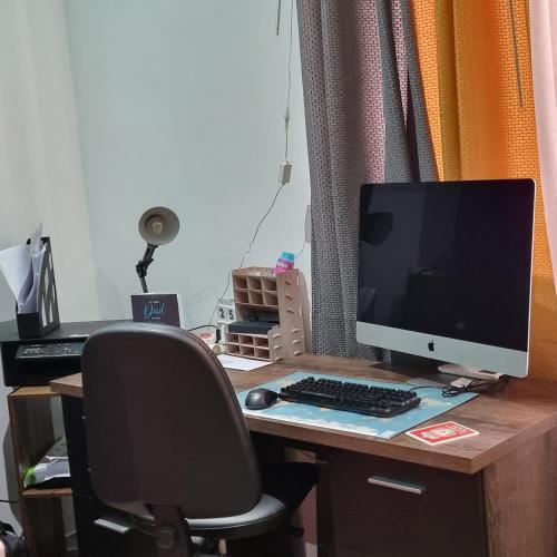 a desk with a computer monitor and a keyboard and mouse at Luqa Premium Rooms in Luqa