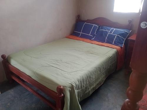 Una cama pequeña con almohadas azules en un dormitorio en TINKUNAKAMA en Humahuaca