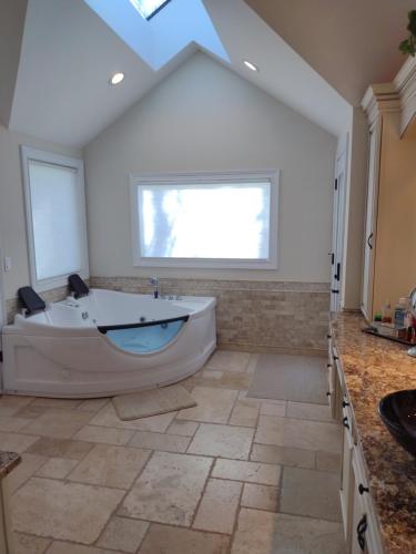 a large bathroom with a large tub and a window at Golf Course Home - New Listing in Mason