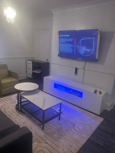 Pokój ze stołem i telewizorem na ścianie w obiekcie Modern 4 Bed House for 9 guests w mieście Tilbury