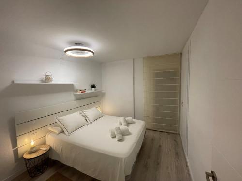 Un dormitorio con una cama blanca con toallas. en Vitaly Beach, en Cambrils