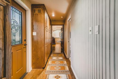 a hallway with a tile floor and a yellow door at The Camp Blanco by Lodgewell - Riverfront retreat 2 Homes, Bunk House, Game Room & more in Blanco