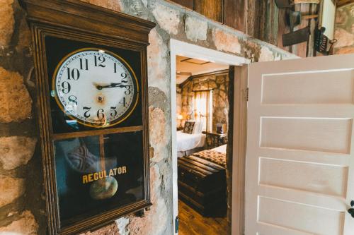 a clock on a wall next to a bedroom at The Camp Blanco by Lodgewell - Riverfront retreat 2 Homes, Bunk House, Game Room & more in Blanco