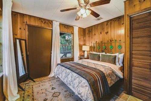 a bedroom with a bed and a ceiling fan at The Camp Blanco by Lodgewell - Riverfront retreat 2 Homes, Bunk House, Game Room & more in Blanco